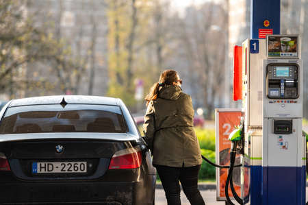 Riga, Latvia, November 2, 2021: a woman refuels a car at a Neste unmanned petrol stationのeditorial素材
