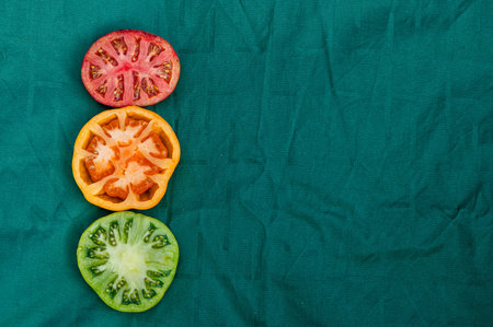 red, yellow and green tomato halves on a green background, close-up from above, abstract semaphoreの写真素材