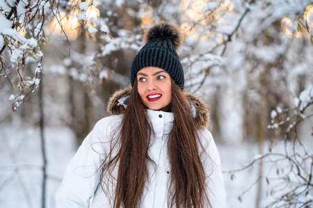 young woman walking in the snowy winter day outdoor, winter forest landscape backgroundの写真素材