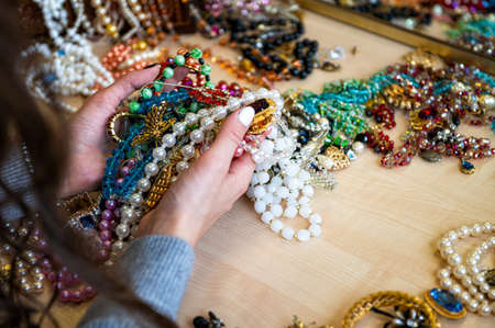 female hands holding a pile of jewelry, closeupの写真素材