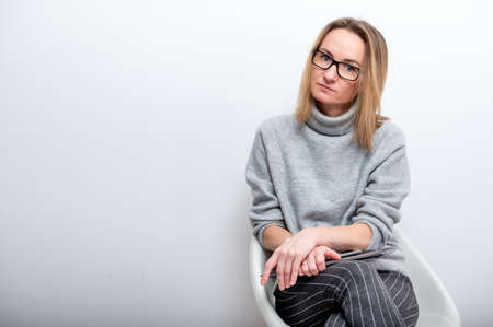 portrait of a blond woman with glasses, isolated on a gray backgroundの写真素材