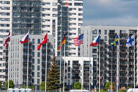 Riga, Latvia, June 01, 2021: flags of hockey championship participants at the ice hall, in the background new business districtのeditorial素材