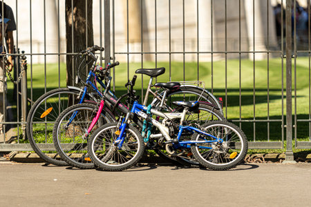 Pisa, Italy - August 9, 2021: bicycles of different sizes left at the fence
