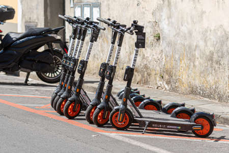 Pisa, Italy - August 9, 2021: A row of HELBIZ electric scooters for rent on the side of the streetのeditorial素材