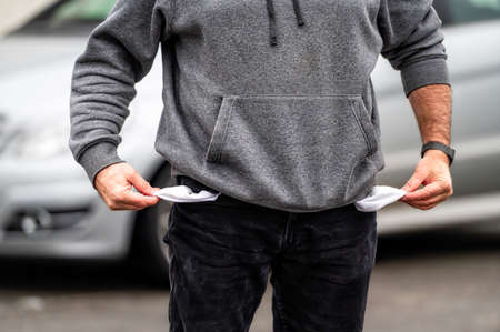 man showing empty pockets, close-up, the concept of unemployment, bankruptcy or financial crisis