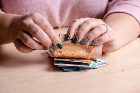 business, finance, saving, banking and people concept - closeup of woman hands counting euro money