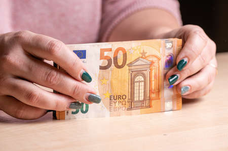 business, finance, saving, banking and people concept - closeup of woman hands counting euro moneyの写真素材