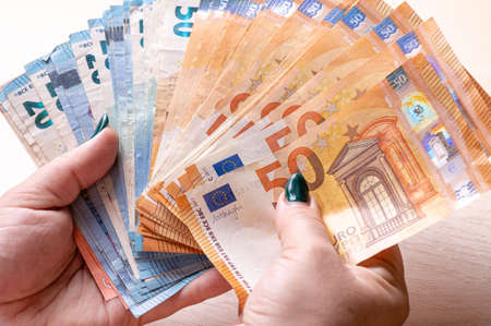 business, finance, saving, banking and people concept - closeup of woman hands counting euro money