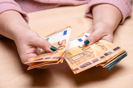 business, finance, saving, banking and people concept - closeup of woman hands counting euro money