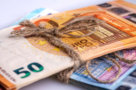 stack of euro banknotes tied with burlap string, closeup, wealth and prosperity conceptの写真素材