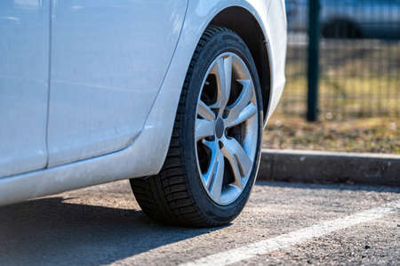 close-up of the rear wheel of a white vehicle parked on the side of the streetの写真素材