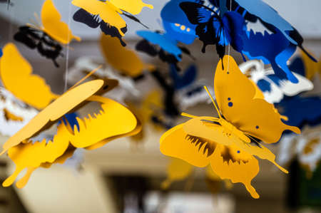 ceiling decorated with decorative colored paper butterflies, selective focus, bokeh, dof, closeupの写真素材