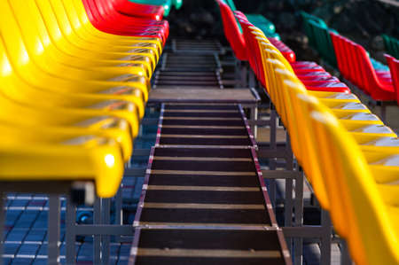 a fragment of the grandstand of an sports stadium with multi-colored seatsの写真素材
