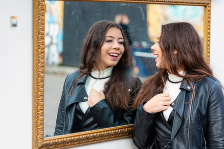 a young, attractive woman makes various grimaces and enjoys her reflection in the mirror