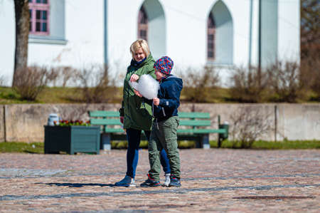 Dobele, Latvia - April 17, 2022: smiling children enjoy cotton candy on the streetのeditorial素材
