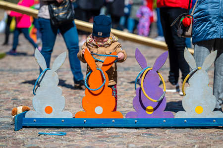 Dobele, Latvia - April 17, 2022: Easter holidays, games for children in the town square, wooden bunny figures for throwing ringsのeditorial素材