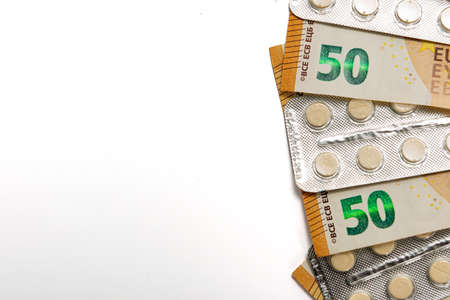 tablets in blister and fifty euro bills isolated on white, expensive healtcare and drugs concept