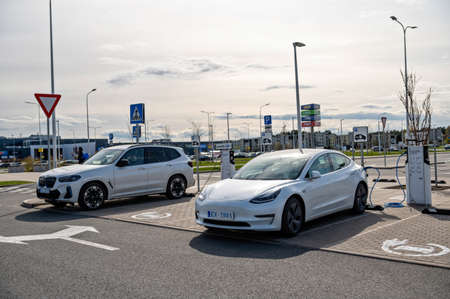 Riga, Latvia, April 29, 2022: electric cars Tesla Model S and BMW ix3 at the charging station in the...