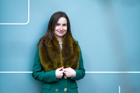 closeup portrait of an elegantly dressed business woman near a blue wall of a modern office building