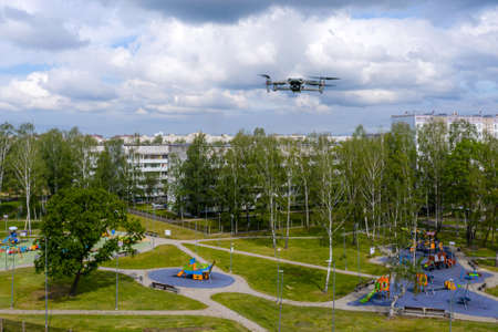 flying drone over the city residential area and childrens playgrounds, modern concept of order...