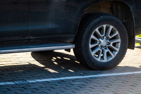 SUV fragment with rear wheel, car shadow on the pavement on a sunny day, closeupの写真素材