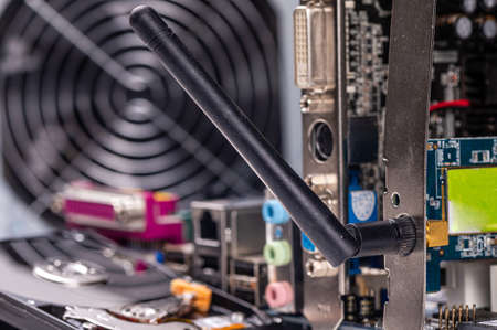 fragment of computer circuit board with components on the background of defocused power supply fans