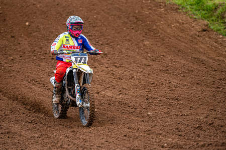 Dobele, Latvia, June 18, 2022: motocross rider in action along the dirt road and hilly terrains, motocross championshipのeditorial素材