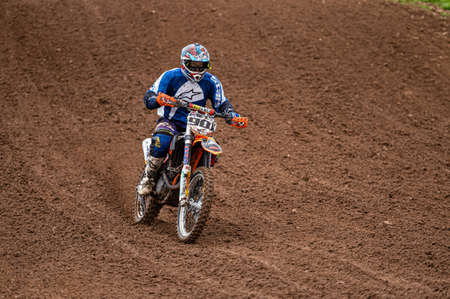 Dobele, Latvia, June 18, 2022: motocross rider in action along the dirt road and hilly terrains, motocross championshipのeditorial素材