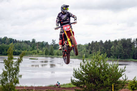 Dobele, Latvia, June 18, 2022: the racer on motocross in flight, jumps and takes off on a...