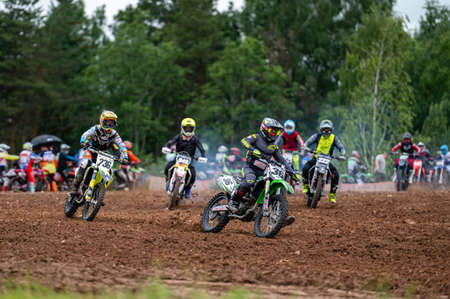 Dobele, Latvia, June 18, 2022: group of motocross riders in action along the dirt road and hilly terrains, motocross championshipのeditorial素材