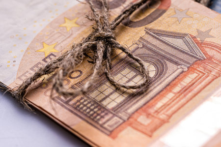 stack of euro banknotes tied with burlap string, closeup, wealth and prosperity conceptの写真素材