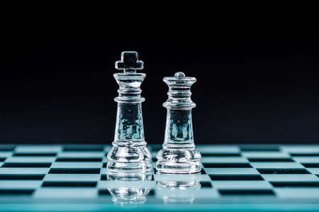 king and queen on the chess board, macro image of glass pieces. Shallow dof, selective focus