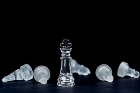 transparent glass chess on black background, selective focus on king piece, close-up