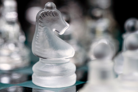 transparent glass chess on dark background, selective focus on knight piece, close-upの写真素材