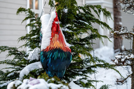 a snowy figure of a rooster and fir trees at the entrance of the cafe, close-upの写真素材