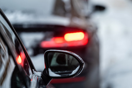 cars parked on snowy street,  rear side view, selective focus on rear view mirrorの写真素材