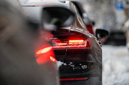 cars parked on snowy street,  rear side view, selective focus on rear lights