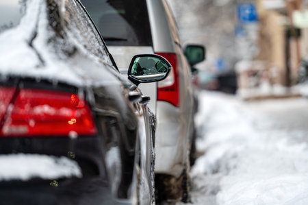 cars parked on snowy street,  rear side view, selective focus on rear view mirrorの写真素材