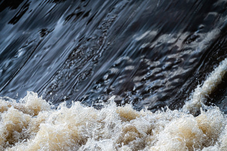 close-up of flowing water, rapid water splashes of an white water river or stream, bubbly water