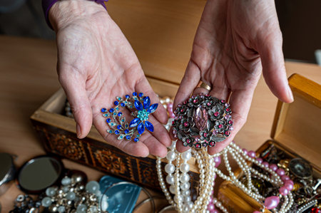 Wooden treasure chest with valuables. A woman holds beads, necklaces and other jewelry in her hands.の写真素材