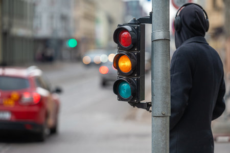 city crossing with a semaphore on blurred background with cars in the evening streets, orange lightの写真素材