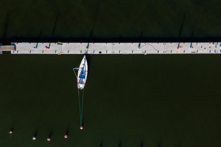 Top view of the yacht in the dock on a dark water backgroundの写真素材