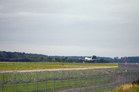 Riga, Latvia - August 31, 2021: AirBaltic Airbus A220-300 YL-AAS landing/arrival in Riga/RIX/EVRA airport on cloudy autumn dayのeditorial素材