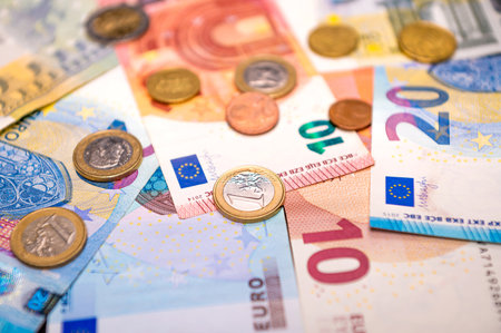 background of banknotes and euro coins of different denominations close-upの写真素材