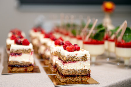 Close-up of cakes with fresh fruits and berries arranged in a row on a party tableの写真素材