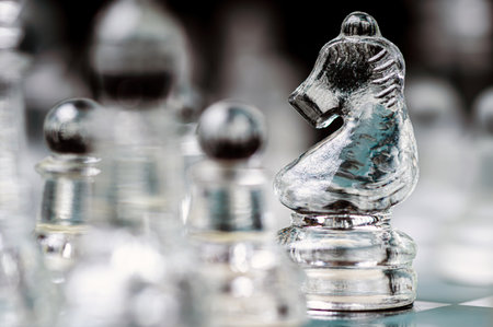transparent glass chess on dark background, selective focus on knight piece, close-upの写真素材
