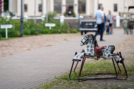 An old childrens spring rocking horse on a defocused background of a historic manor yard.の写真素材