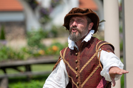 Pakruojis, Lithuania. July 1, 2023: An animator in medieval costume entertains tourists by telling old stories and fables.のeditorial素材
