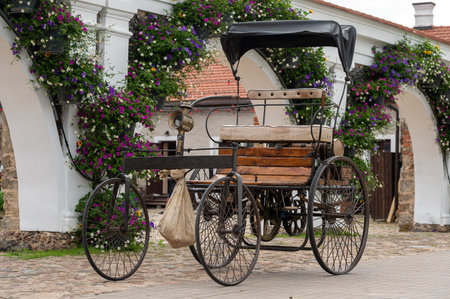 Pakruojis, Lithuania. July 1, 2023: Pakruojis Manor Park. An ancient four-wheeled motor carriage to the wallのeditorial素材