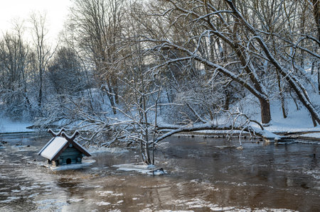 spring floods and ice melt in a small river, waterfowl feeder flooded as water level rises, Latviaの写真素材